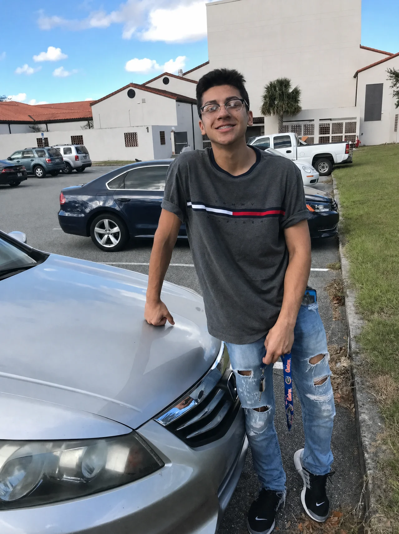 Luis in 2017 while working minimum wage at McDonald's, standing by a used Honda